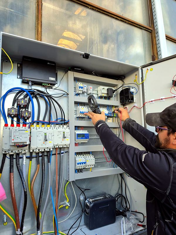 Electrician DILAN verificând tabloul electric cu clește ampermetric